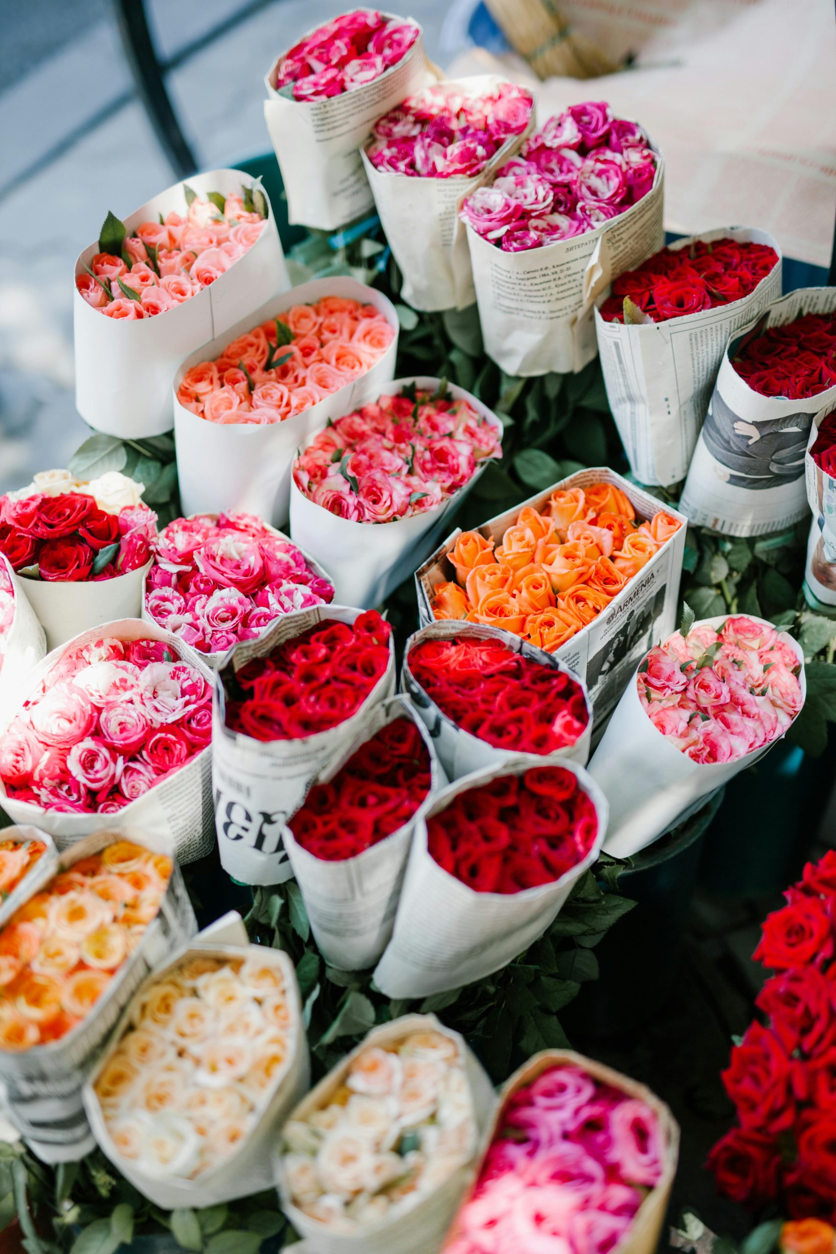 From above set of various colorful bouquets of roses wrapped in paper in florist shop